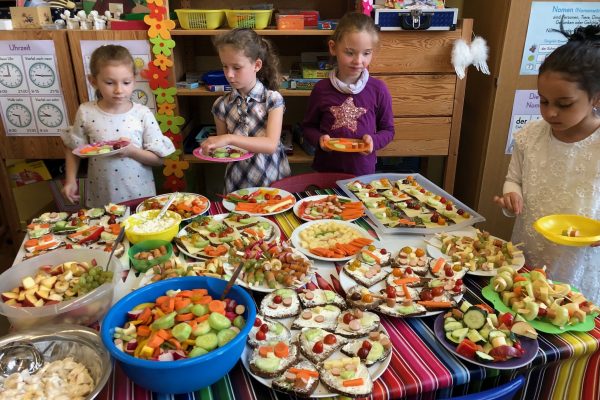 Kinder vor einem üppigen gesunden Frühstücksbuffet