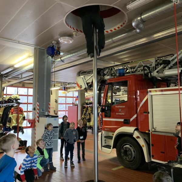 bei einem Einsatz rutscht der Feuerwehrmann die Stange herunter