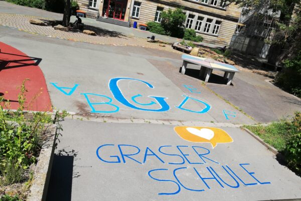 Blick auf das Graserschullogo in der Hofeinfahrt