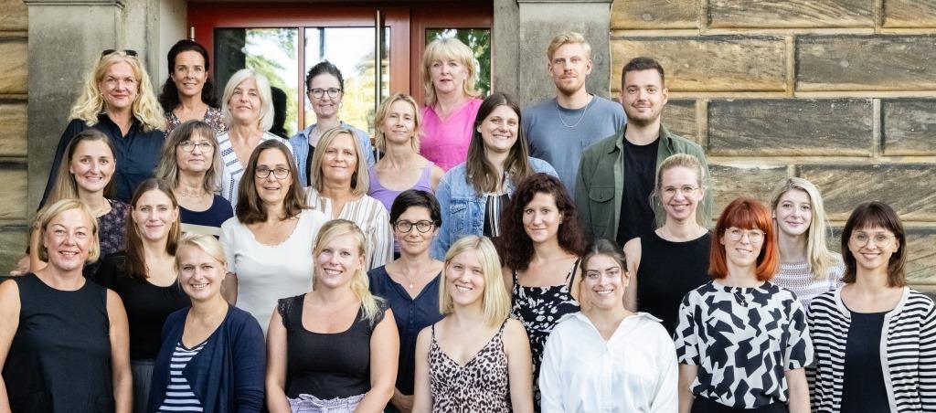 Lehrerinnen stehen vor dem Eingang der Schule