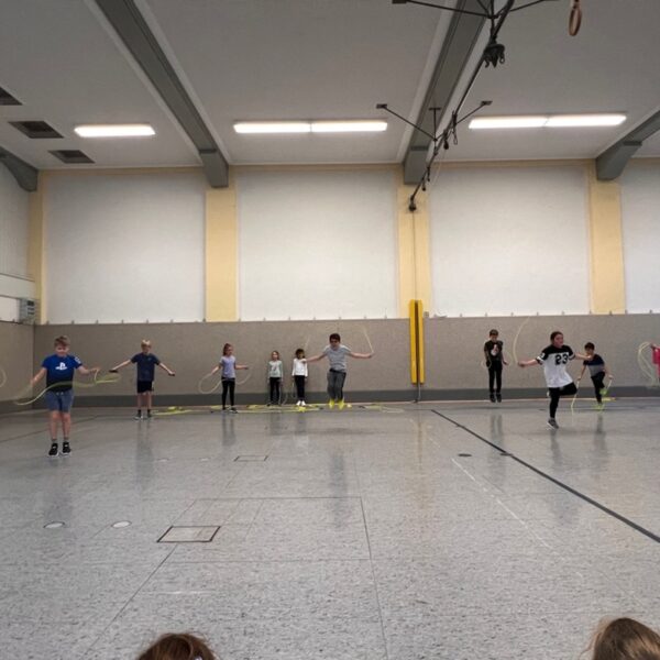 Kinder in der Turnhalle, die Seil springen