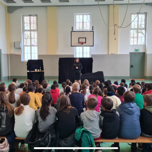 Viele Kinder in der Turnhalle schauen dem Theater zu