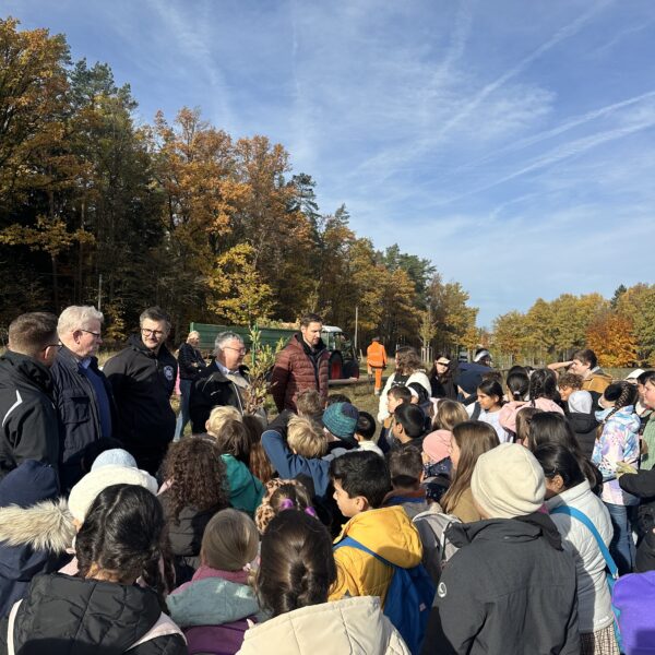 Menschen auf einer Wiese, die dem Bürgermeister zuhören