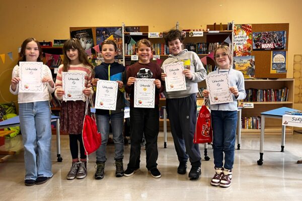 6 Kinder der 4. Klassen, die ihre Urkunde vom Vorlesewettbewerb hochhalten