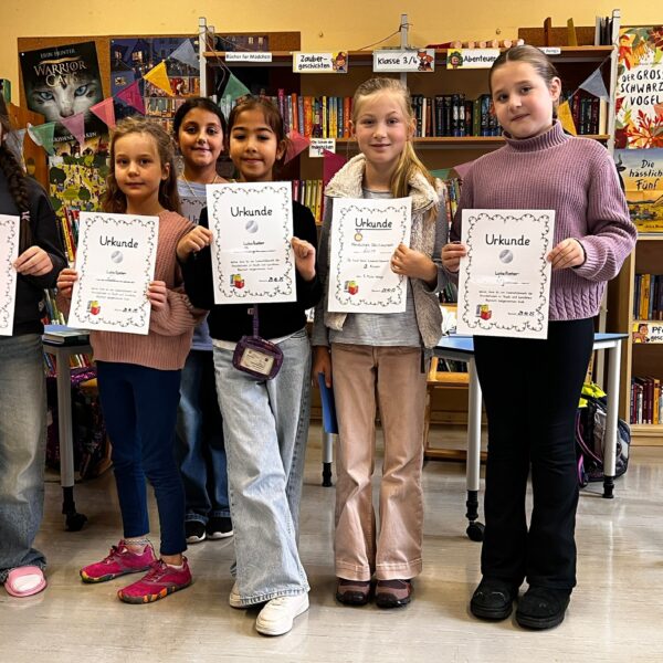 6 Kinder der 3. Klassen vom Vorlesewettbewerb, die ihre Urkunden hochhalten