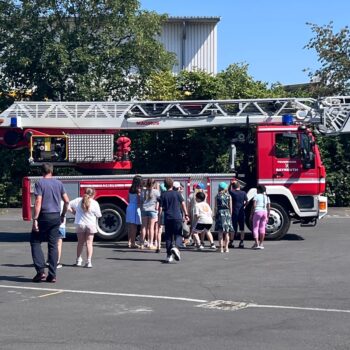 Kinder vor einem Feuerwehrauto