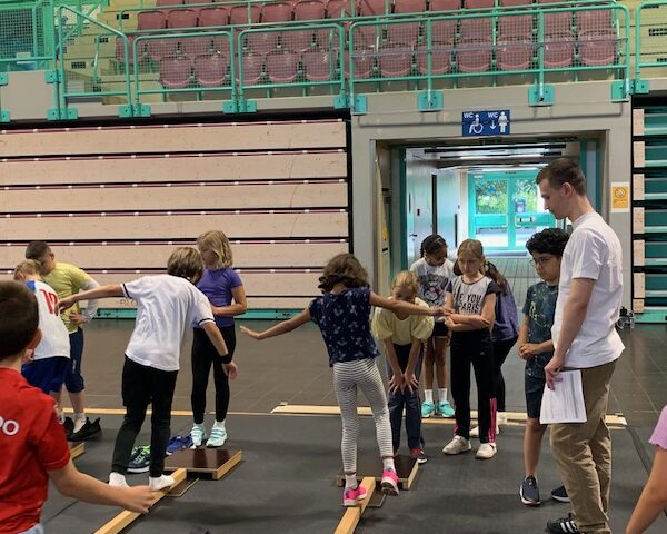 Kinder balancieren auf einem Balken in der Oberfrankenhalle