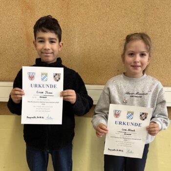 2 Kinder halten eine Urkunde in der Hand