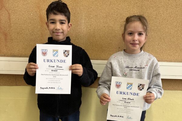 2 Kinder halten eine Urkunde in der Hand